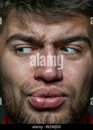 Close up portrait of young man et émotionnel. Détail de sem - allemand très modèle masculin avec la peau bien entretenu et lumineux de l'expression du visage. Concept d'émotions humaines. Sensation dégoûtante. Banque D'Images