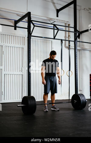 Athletic homme debout sur barbell in gym préparez à soulever Banque D'Images