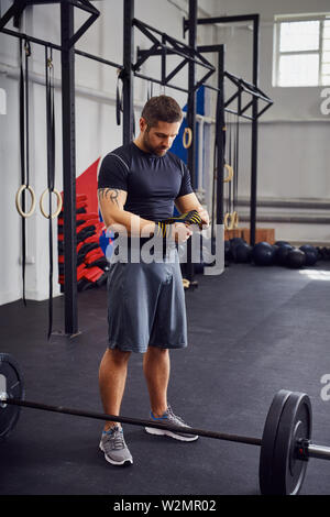 Jeune homme de préparer dans la salle de sport avant la formation de force Banque D'Images