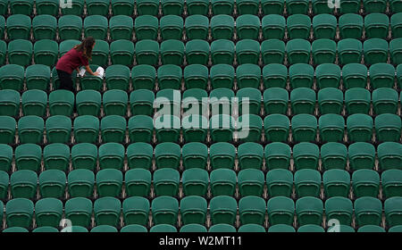 Le personnel de nettoyage nettoie les sièges sur le court 2 le neuf jour des championnats de Wimbledon au All England Lawn tennis and Croquet Club, Londres. Banque D'Images