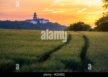 Pannonhalma Archabbey avec champ de blé et le chemin sur l'heure du coucher du soleil en été Banque D'Images