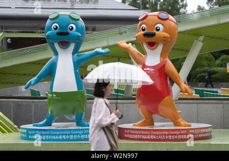 Gwangju, Corée du Sud. 10 juillet, 2019. Les mascottes du championnat du monde de natation, deux loutres, debout sur un seul lieu par temps de pluie. Crédit : Bernd Thissen/dpa/Alamy Live News Banque D'Images