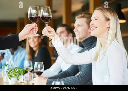 Jeune femme sur une célébration au restaurant avec des amis tout en grillage avec du vin rouge Banque D'Images