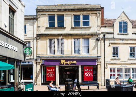 L'avant de la boutique de mode de la Mousson à Trowbridge, Wiltshire rouge avec de grandes affiches vente de 50 pour cent dans les fenêtres. Banque D'Images