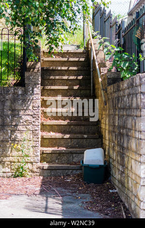 En dehors des mesures concrètes avec un bol en plastique et une bouteille en bas menant à un chemin d'accès autochtones gardens Banque D'Images