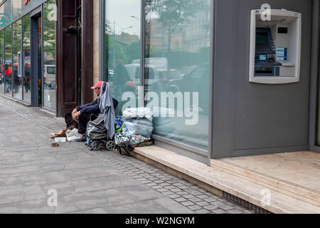 Budapest, Hongrie - le 27 mai 2019 : Sans-abri avec chien assis par le mur de l'édifice, sur la rue de Budapest, Hongrie Banque D'Images