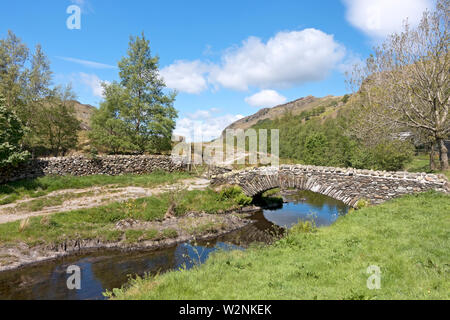 Pont en pierre à travers Watendlath Beck en été Lake District National Park Cumbria Angleterre Royaume-Uni Grande-Bretagne Banque D'Images