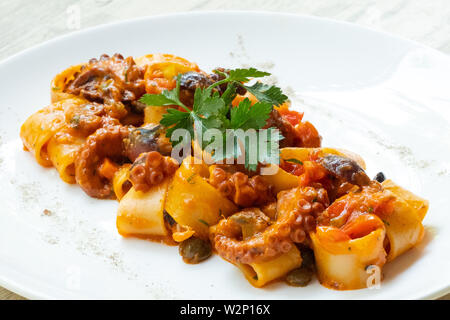 Close up of octopus calamarata pâtes italiennes faites maison sicilienne sauce aux fruits de mer à la tomate basilic,persil,herbes,froid,préparé par profession Banque D'Images