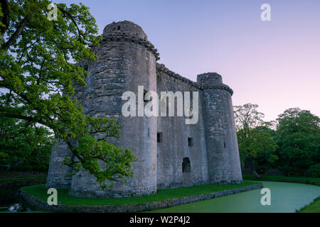 Nunney Castle moat et dans le village de Nunney, Somerset, Angleterre. Banque D'Images