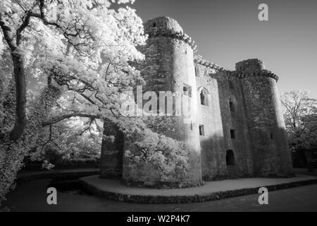 Une image en noir et blanc de Nunney Castle moat et dans le village de Nunney, Somerset, Angleterre. Banque D'Images