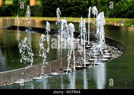 Fontaine d'eau moderne abstrait libre avec la réflexion en milieu urbain ou de la société de l'hôtel bâtiment de bureaux au centre-ville de ville Banque D'Images