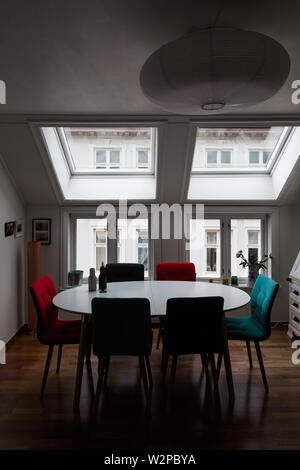 Scandinavian salle à manger avec table et chaises par de grandes fenêtres. Banque D'Images