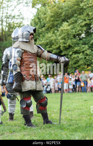 Nis, Serbie - 15 juin. 2019 chevaliers en armure de fer et le casque et la tenue de l'épée à la main sur le champ de bataille. Reconstruction de batailles chevalier Banque D'Images