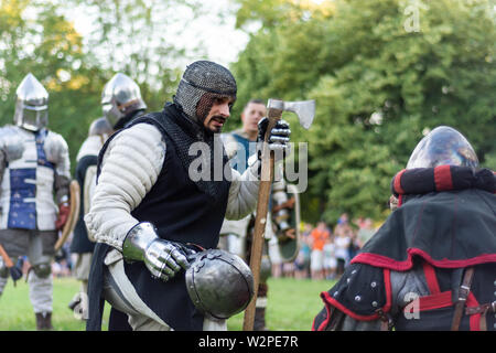 Nis, Serbie - 15 juin. 2019 Knight avec une hache et un casque dans la main indique à l'autre chevalier. Reconstruction de batailles knight sur le festival Banque D'Images