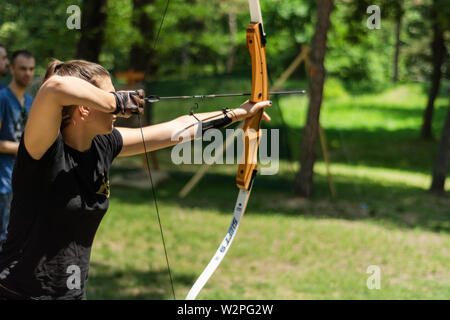 Nis, Serbie - 16 juin. 2019 fille professionnel archer à l'arc tirer flèche dans la forêt sur knight festival et tournoi. Bowman avant le tournage Banque D'Images