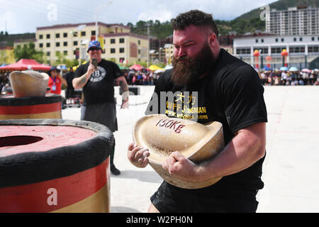 (190710) -- DIEBU, 10 juillet 2019 (Xinhua) -- l'Angleterre de Macauley Tinker fait concurrence au cours de la 'Hugging Inpot' match de l'homme le plus fort 2019 Diebu Concours International Open de Chine à Diebu, nord-ouest de la Chine, la province de Gansu, le 10 juillet 2019. (Xinhua/Chen Bin) Banque D'Images