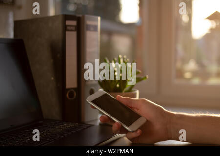 Jeune blogueur travaille avec smart phone dans son bureau à domicile. Concept pour les jeunes hommes d'. mode de vie occupé à designer les mains. Freelancer concept Banque D'Images