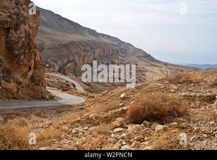 Route étroite à Wadi Bin (Ibn) Hammad (Jordanie), profondément érodé dans les rochers, est doté de façon permanente par les ressorts (chaud). Il mounds dans la mer Morte. Banque D'Images