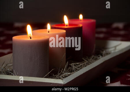 Décoration de Noël ordinaire avec l'avènement des bougies. Les quatre bougies de Noël éclairé. Noël arrière-plan Concept. Bougies colorés traditionnels. Banque D'Images