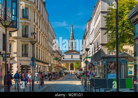 Vue sur la rue de Rue du Commerce avec ses boutiques et le néo-gothique de l'Église catholique Église Saint-Jean-Baptiste de Grenelle à la fin de la route sur un... Banque D'Images