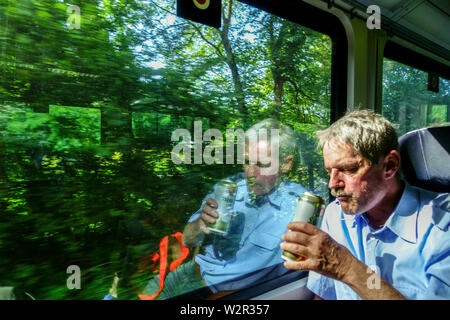 Fenêtre de train, Un passager dans le train boit de la bière à partir d'une canette, train régional Allemagne Europe train touristique allemand Suisse saxonne train nature Banque D'Images