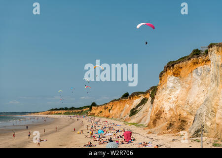 Les parachutes sur une plage de sable fin sur une côte escarpée en France Banque D'Images