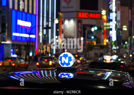 Toit de taxi et de néon enseignes publicitaire dans la nuit dans le quartier de Shinjuku, Tokyo, Japon. Banque D'Images