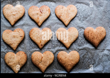 High angle close up de cookies en forme de hart sur du papier sulfurisé. Banque D'Images