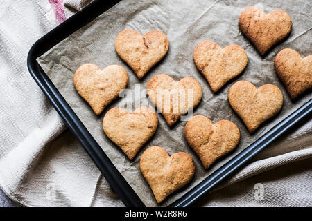 High angle close up de cookies en forme de hart sur plaque de cuisson. Banque D'Images