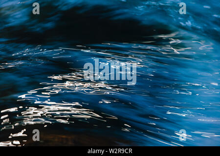 Abstract close up de rivière qui coule de l'eau avec reflets de lumière sur la surface. Banque D'Images