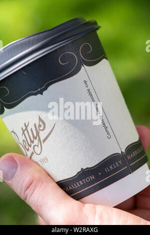 Main tenant une bettys de papier compostables tasse à Harrogate RHS Flower show 2019 Harlow carr, Harrogate, England Banque D'Images