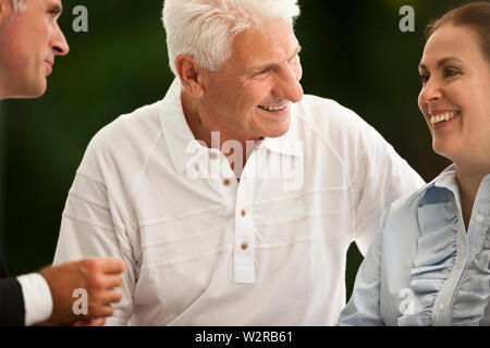 Senior couple having une réunion sur leur terrasse avec un homme d'affaires. Banque D'Images