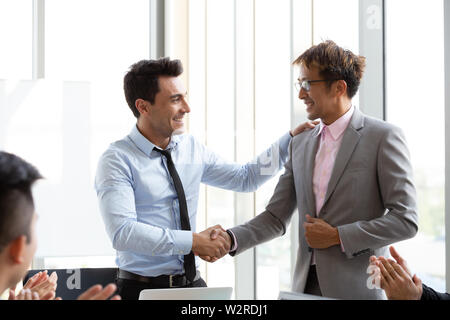 Poignée de main entre le chef de l'étranger et de l'Asian manager qui peut mener à bien le projet qui fait de l'entreprise tirer profit de l'assemblée Banque D'Images