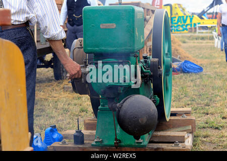 Kama & Mac Gregor, en Finlande. Le 6 juillet 2019. L'homme ajuste John Deere Waterloo Boy K moteur stationnaire qui opère sur la batteuse ancienne Kama & Mac Gregor 2019 traktorkavalkad. Banque D'Images