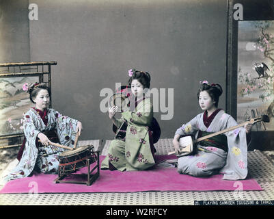 [ 1890 - Japon Maiko (apprenti Geisha) Jouer de la musique ] - Maiko en kimono et coiffures traditionnels jouant tsutsumi (également tsuzumi) batterie de l'épaule, shamisen, un instrument de musique à trois cordes, et un tambour taiko connu comme ootsutsumi. 19e siècle vintage albumen photo. Banque D'Images