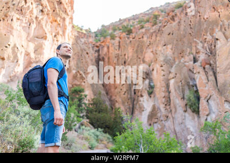 Avec l'homme du parc randonnées sur sentier en boucle principale en chemin Bandelier National Monument au Nouveau Mexique en été par canyon falaise Banque D'Images