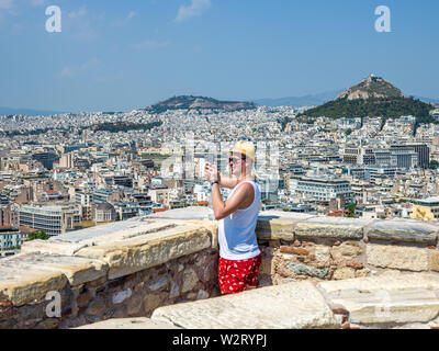 Athènes, Grèce, 9 juillet 2019 - un touriste prend des photos de la capitale grecque Athènes du haut de l'Acropole. Photo par Enrique Shore/Alamy Stock Photos Banque D'Images