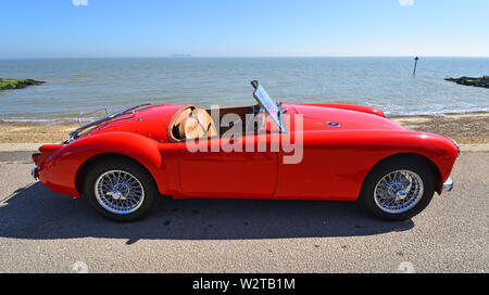 Rouge Classique MG une automobile stationnée sur promenade du front de mer. Banque D'Images