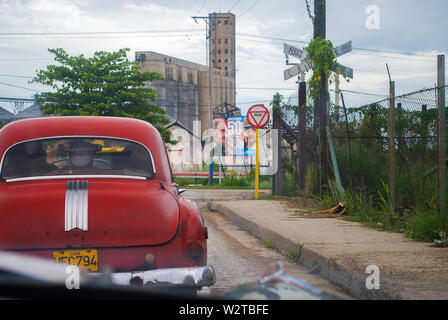 La Havane - Cuba / 16 octobre 2011, de meubles anciens d'un siècle d'âge voiture américaine rempli de Cubains à la périphérie de La Havane avec un poster dans la politique Banque D'Images