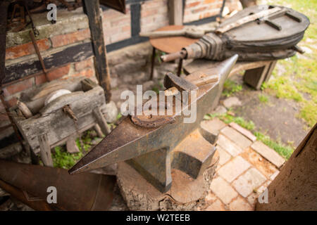 Outils dans un ancien atelier de forgeron. Horseshoe et marteau sur une grande enclume. Place - musée en plein air. Banque D'Images