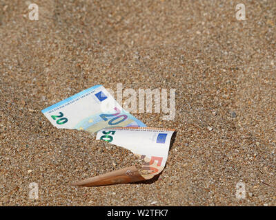 Cinquante et vingt euros dans le sable sur la plage with copy space Banque D'Images