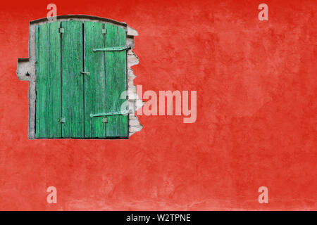 Fenêtre verte rouge sur mur en stuc. Couleur rouge vif accueil maison avec façade en bois vert et grande fenêtre mur rouge vide vide texture background Banque D'Images