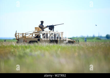 Boboc, Roumanie - 22 mai 2019 : soldats roumains homme un véhicule blindé Humvee sur un champ, sur une journée ensoleillée durant un exercice. Banque D'Images