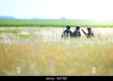Boboc, Roumanie - 22 mai 2019 : des soldats de l'armée roumaine une patrouille dans un champ, le long d'une journée d'été au cours d'un exercice d'évacuation. Banque D'Images