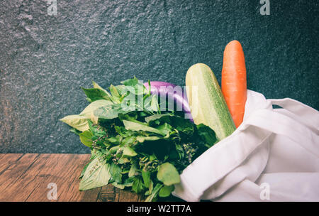 L'utilisation des déchets zéro moins de plastique concept / légumes frais biologiques dans des sacs en tissu de coton eco sur table en bois blanc - toile fourre-tout sac en tissu de fre marché Banque D'Images