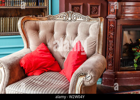 Intérieur classique de luxe accueil bibliothèque. Salon avec bibliothèque, livres, Fauteuil, canapé et cheminée. Décoration moderne et propre avec un élégant f Banque D'Images