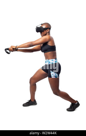 Athletic woman tout en jouant le jeu vidéo VR en pratiquant les combats à l'épée ou l'escrime avec un casque de réalité virtuelle et du contrôleur. Montre Banque D'Images