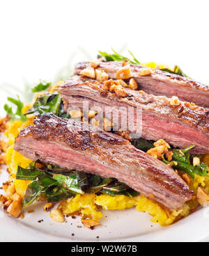 Bavette de boeuf avec de la purée de banane plantain , chou vert et le gingembre arachides , close up Banque D'Images