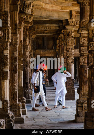 NEW DELHI, INDE - circa 2018 Novembre : Les habitants de marcher autour des sculptures sur pierre sur le cloître colonnes à la mosquée Quwwat ul-Islam du Qutb M Banque D'Images