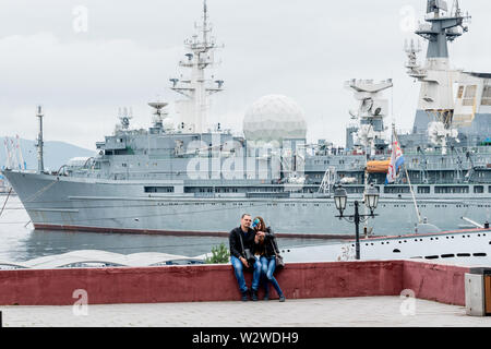 La Russie, Vladivostok, 07/06/2019. Jeune et heureux couple fait fond sur les selfies du port maritime et de l'instrumentation de missiles navire 'Marshal gamme Zhoukov' Banque D'Images